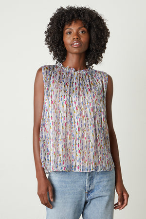 The model is wearing a Velvet by Graham & Spencer NADINE PRINTED LUREX STRIPE TANK TOP with a multi-colored print.