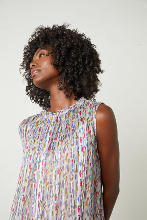 a black woman with curly hair wearing the Velvet by Graham & Spencer NADINE PRINTED LUREX STRIPE TANK TOP.