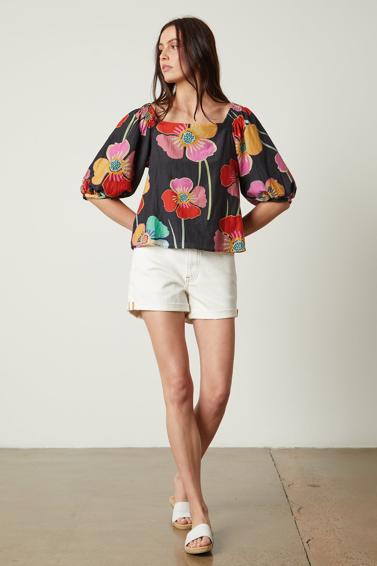   Jasmine Top in bold floral with black background and white denim shorts with white slides full length front 