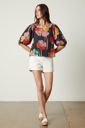 Jasmine Top in bold floral with black background and white denim shorts with white slides full length front