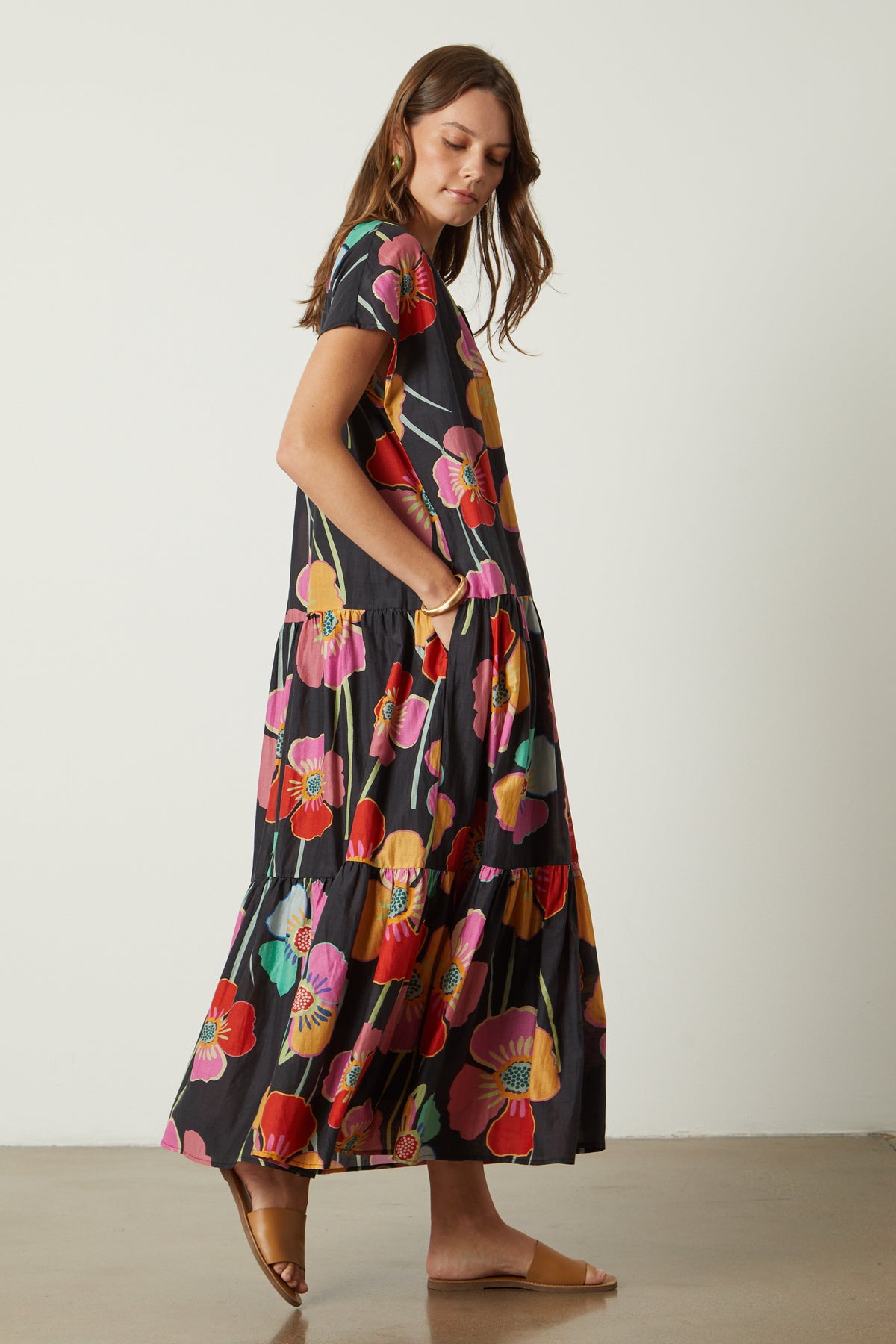 Savannah Maxi Dress in bold floral print on black background full length side untied model with hand in dress pocket-26233476448449