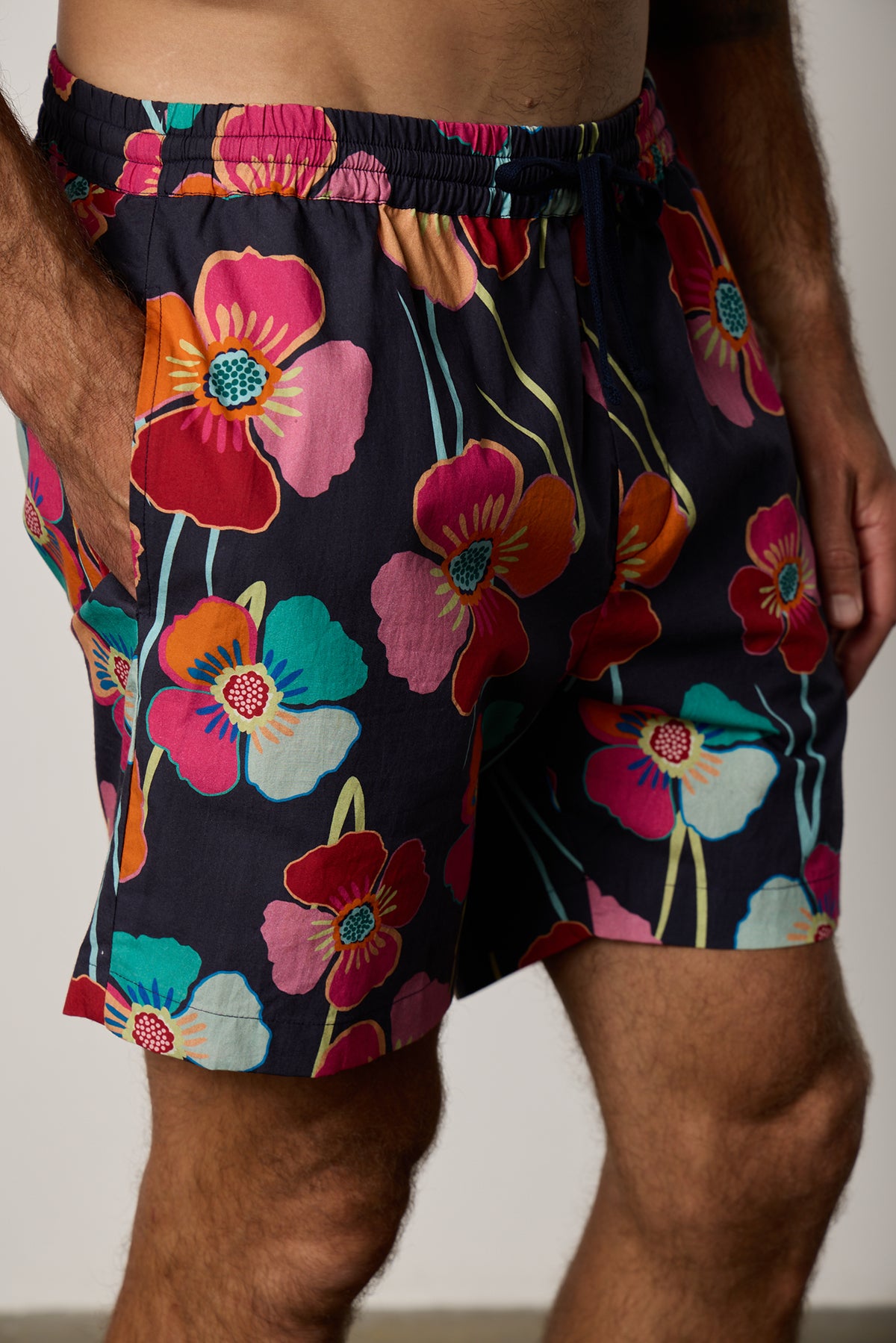   Colt Short front & side in bahama print with bold, multi colored floral pattern with dark background close up detail with model's hand in pocket 
