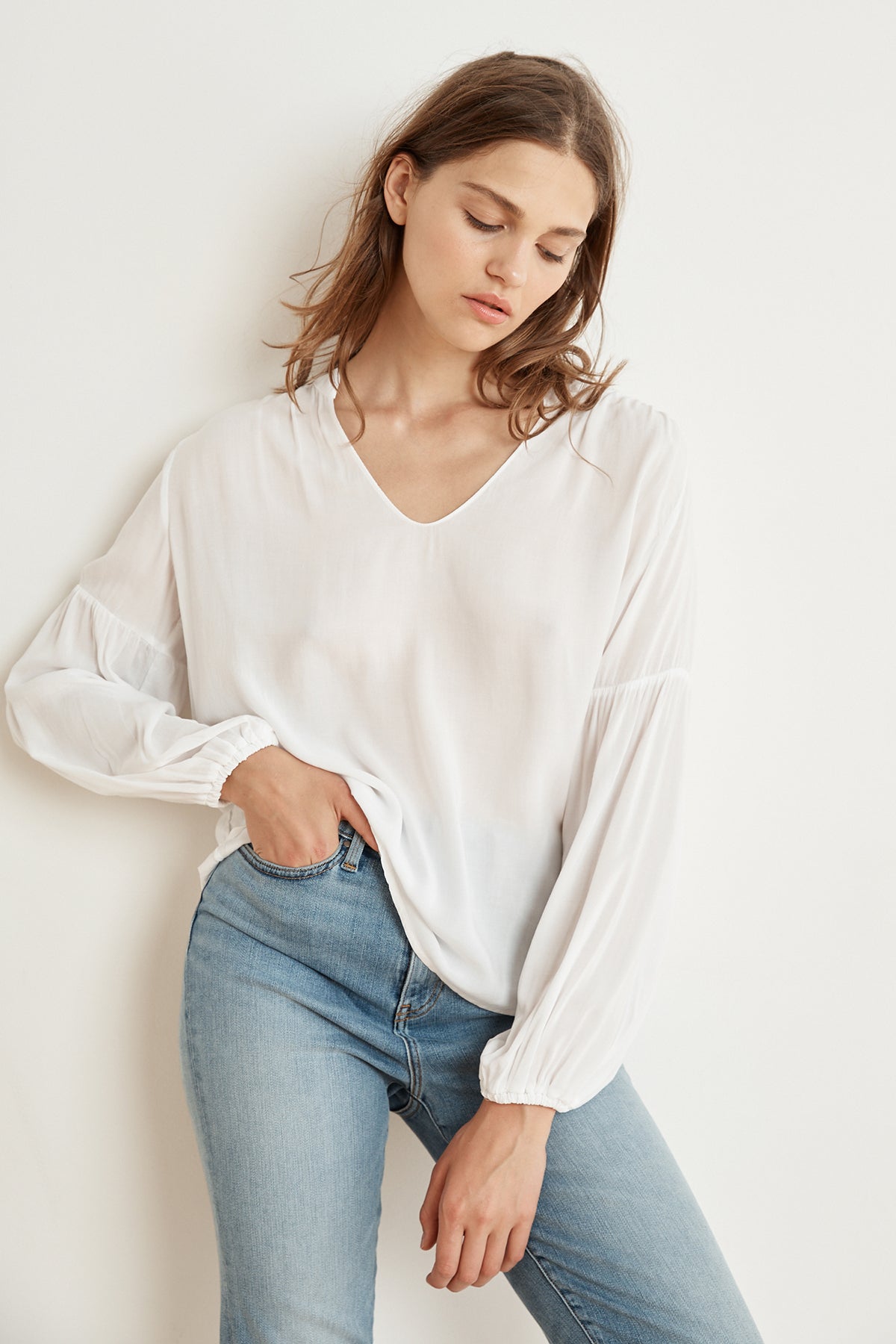 The model is wearing a YULIA RAYON CHALLIS PEASANT SLEEVE BLOUSE by Velvet by Graham & Spencer.-1147602632785