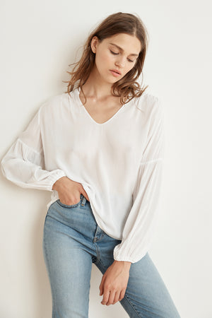 The model is wearing a YULIA RAYON CHALLIS PEASANT SLEEVE BLOUSE by Velvet by Graham & Spencer.