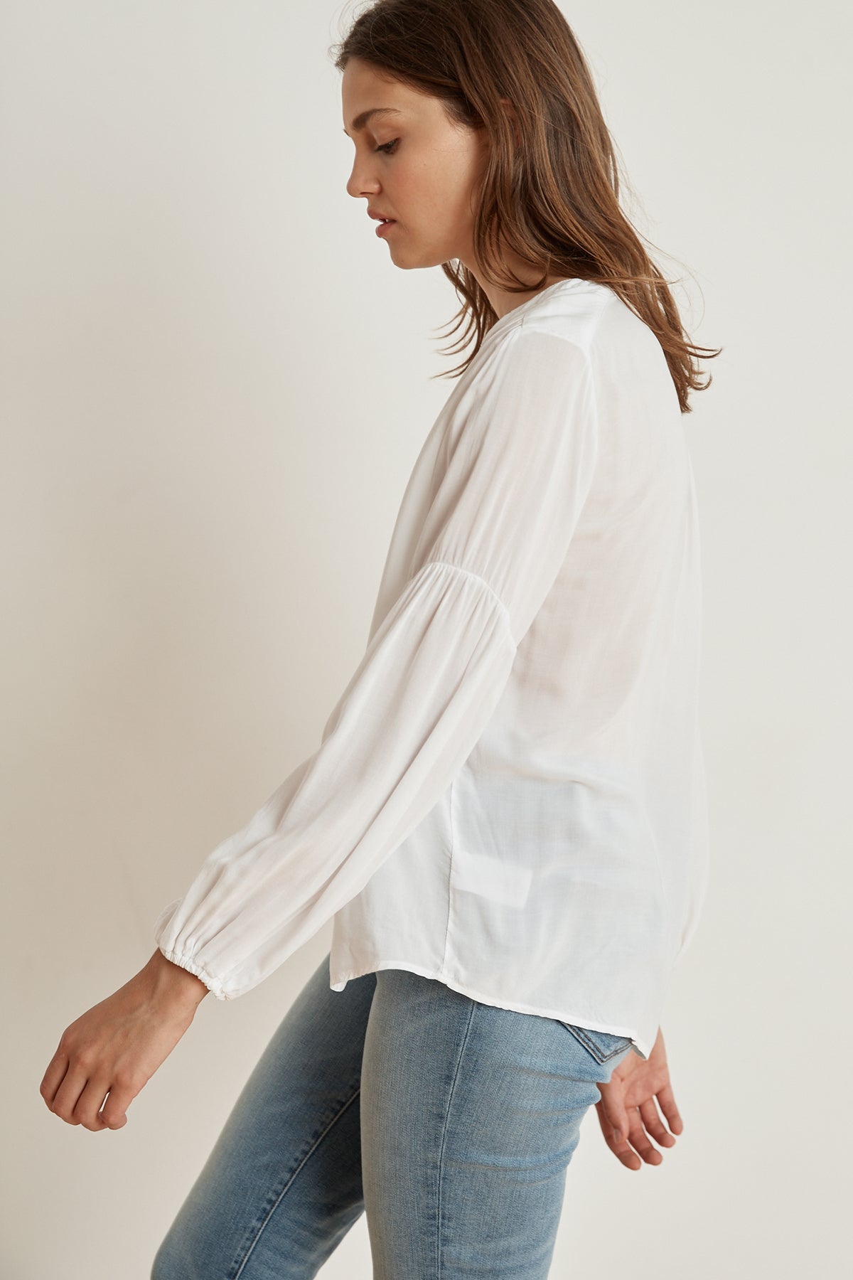   The model is wearing a YULIA RAYON CHALLIS PEASANT SLEEVE BLOUSE by Velvet by Graham & Spencer, which adds a breath of fresh air to her outfit. 