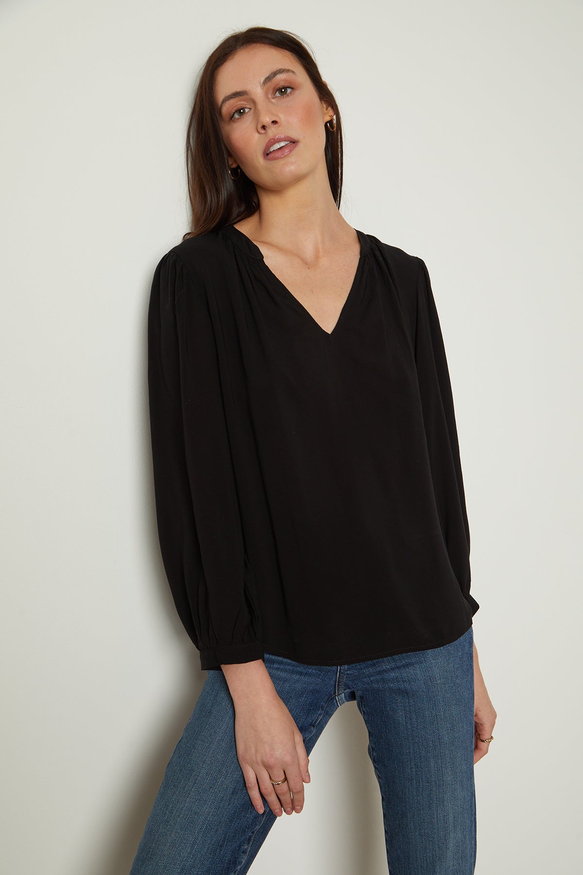 A woman wearing a Velvet by Graham & Spencer EMILY V-NECK BLOUSE and jeans.-25954485665985