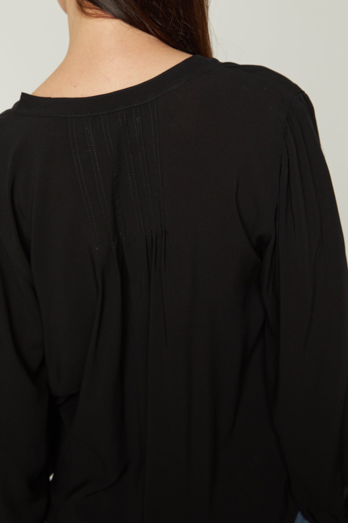   the back view of a woman wearing an EMILY V-NECK BLOUSE from Velvet by Graham & Spencer. 