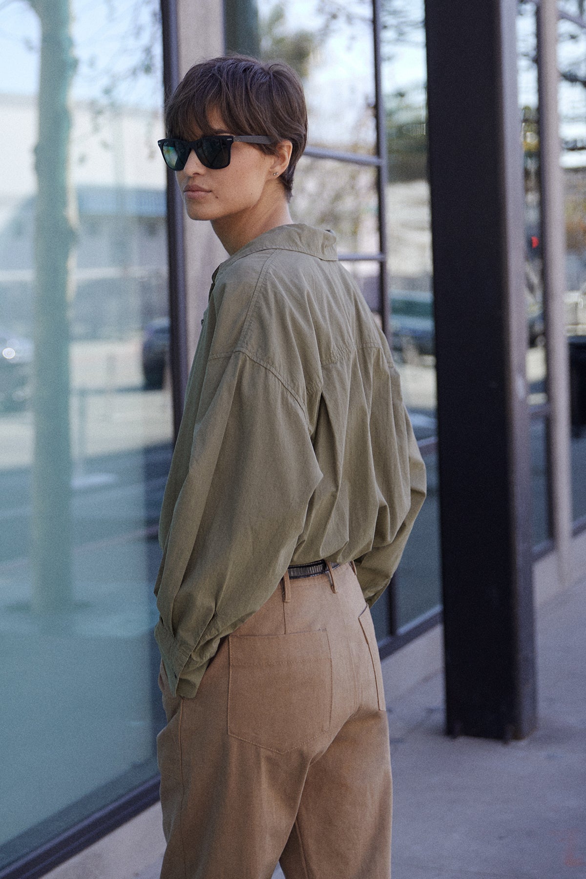 Redondo Shirt in thicket with Ventura Pant side & back, model wearing sunglasses looking over left shoulder.-25870844166337