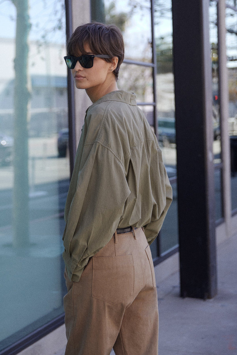 Redondo Shirt in thicket with Ventura Pant side & back, model wearing sunglasses looking over left shoulder.