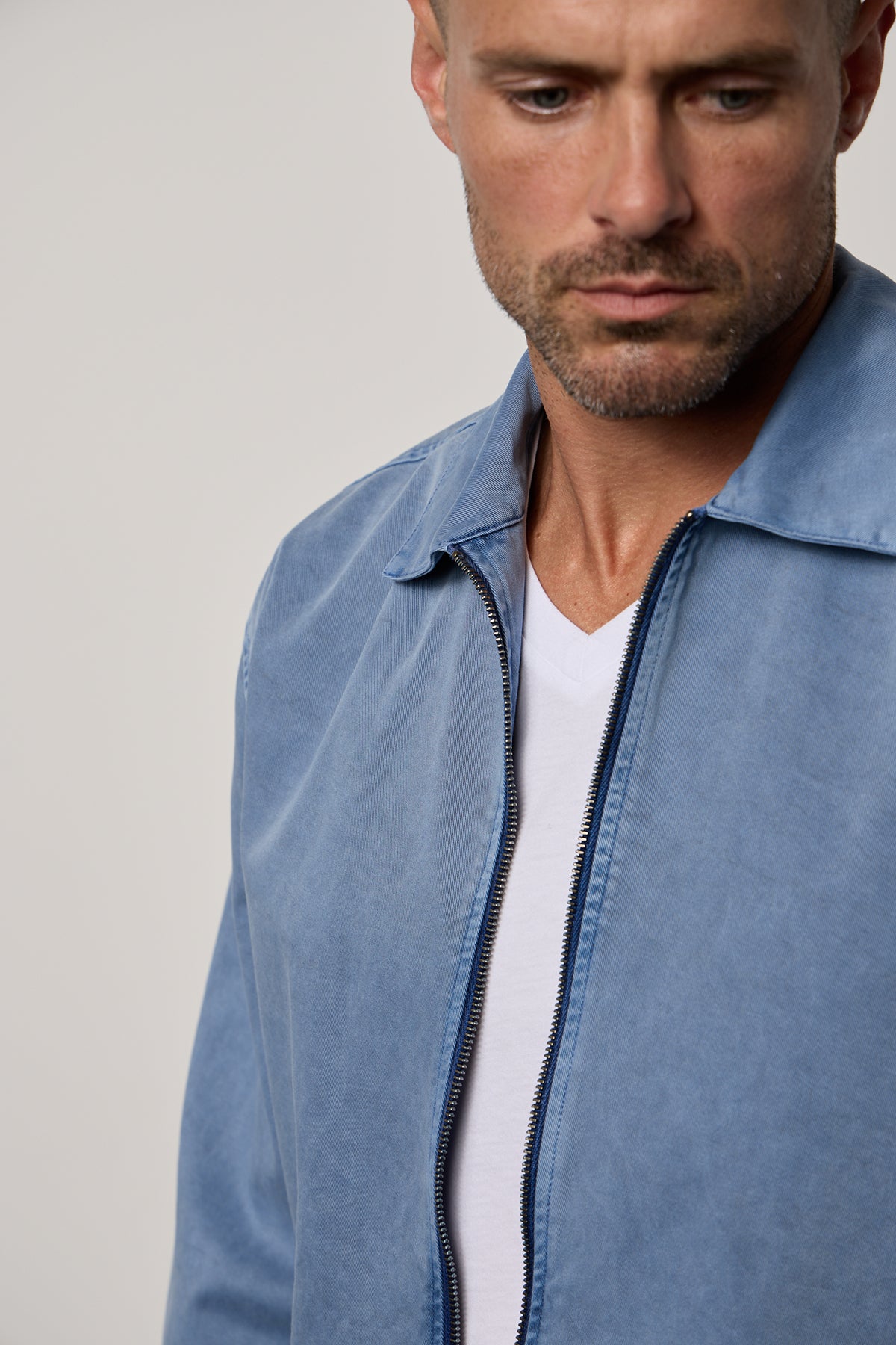   A man wearing a Velvet by Graham & Spencer ODIN SANDED TWILL ZIP-UP JACKET and white t-shirt. 