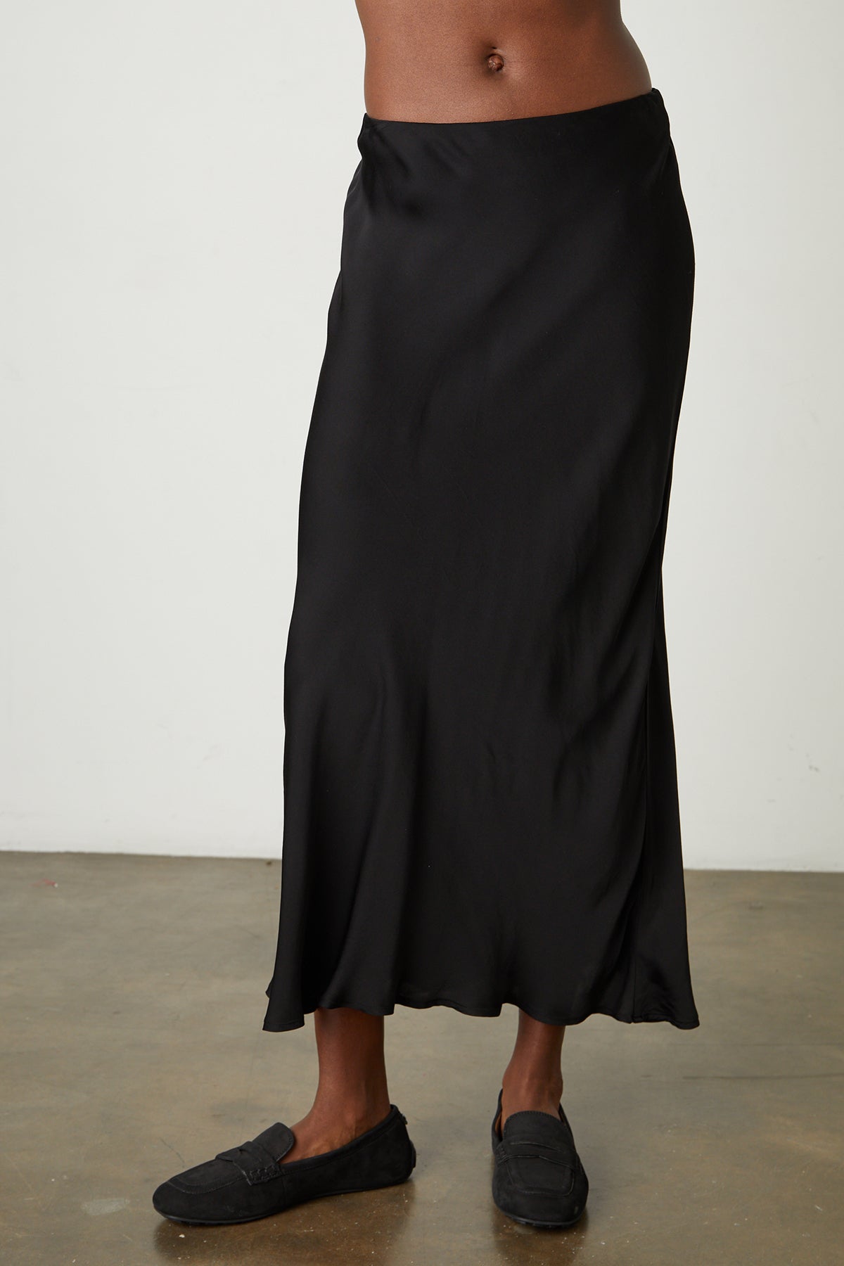a woman wearing a Velvet by Graham & Spencer AUBREE SATIN MIDI SKIRT.-25870893351105