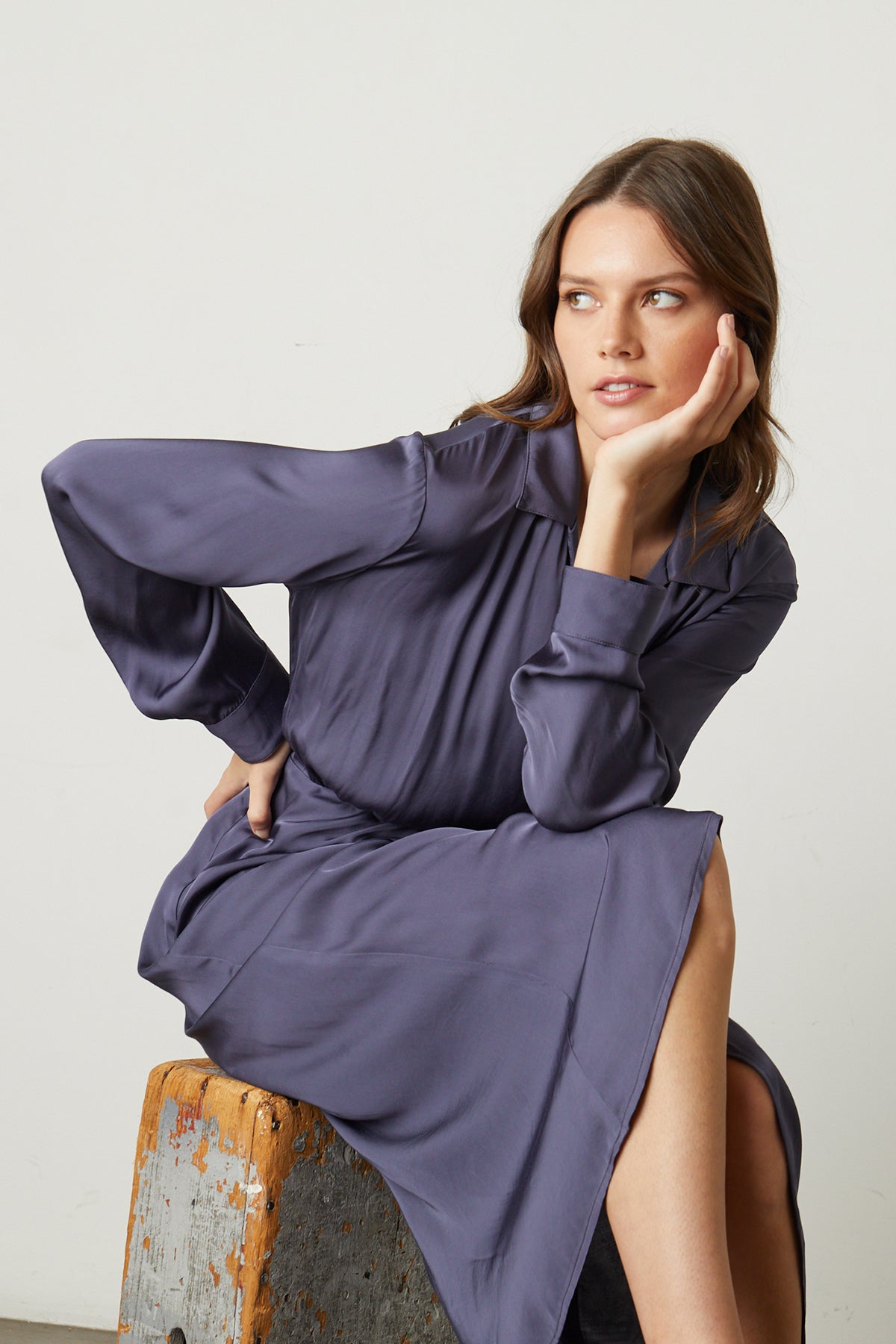 Model sitting on stool wearing Jovie Satin Wrap Dress in steel-25994850402497
