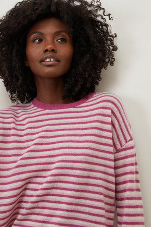 A woman wearing a Velvet by Graham & Spencer CADIE CASHMERE STRIPED SWEATER.
