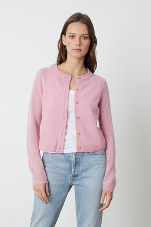a woman wearing a Velvet by Graham & Spencer pink NANI CASHMERE CARDIGAN and jeans.