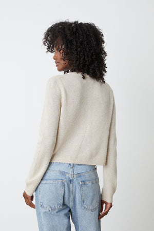The back view of a woman wearing a Velvet by Graham & Spencer NANI CASHMERE CARDIGAN and jeans.