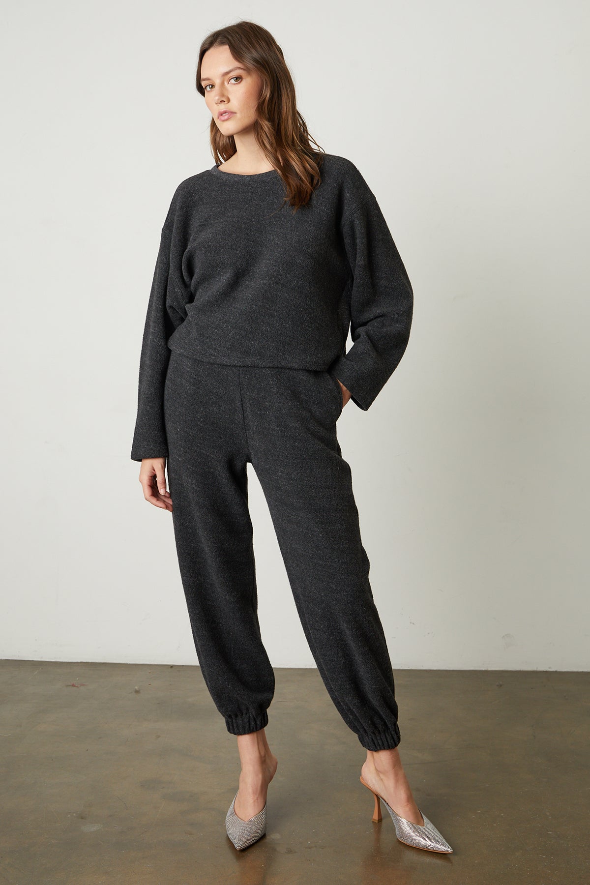   The model is wearing a Charcoal Arissa Cropped Sweatshirt and joggers from Velvet by Graham & Spencer. 