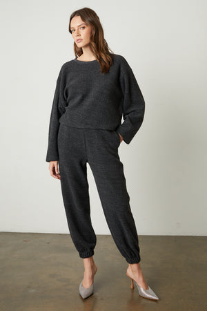 The model is wearing a Charcoal Arissa Cropped Sweatshirt and joggers from Velvet by Graham & Spencer.