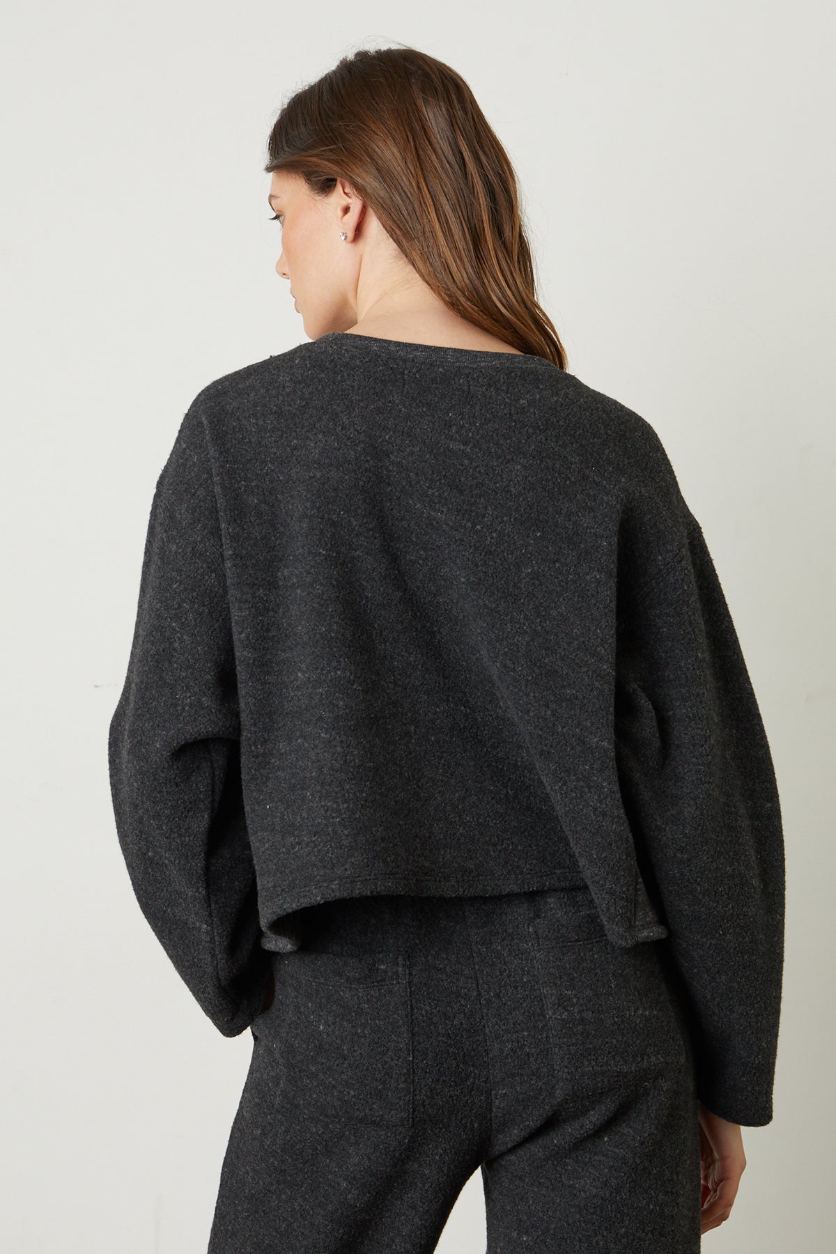 the back view of a woman wearing a Velvet by Graham & Spencer ARISSA CROPPED SWEATSHIRT and pants.-25745169350849