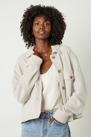 the model is wearing a Velvet by Graham & Spencer KAMERON FLEECE SHACKET and jeans.