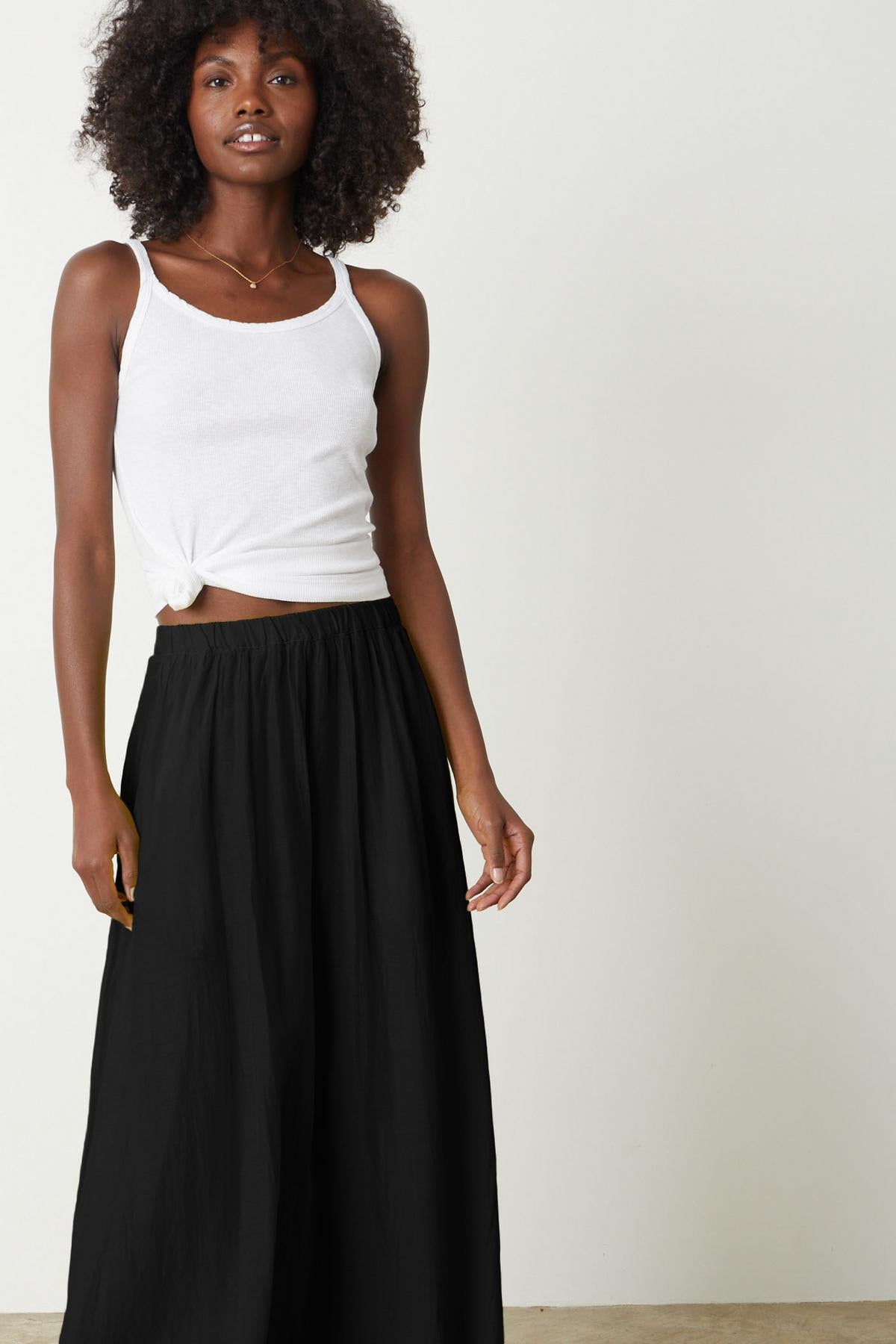 a woman wearing a black Velvet by Graham & Spencer wide leg pant and white top.-26262257795265