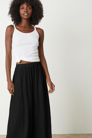 a woman wearing a black Velvet by Graham & Spencer wide leg pant and white top.