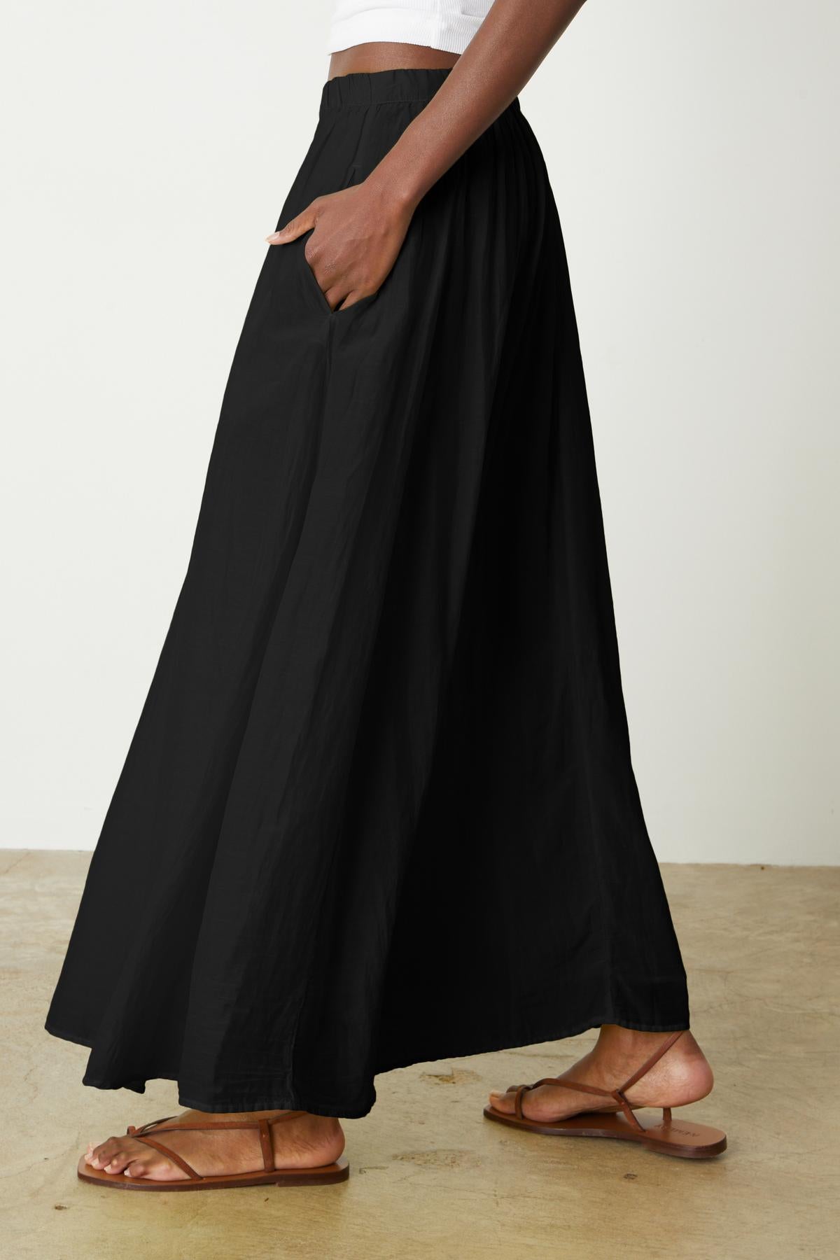   A woman wearing a Velvet by Graham & Spencer Mariela Maxi Skirt with pockets. 