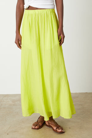 A woman wearing a Velvet by Graham & Spencer Mariela Maxi Skirt in bright citrus green