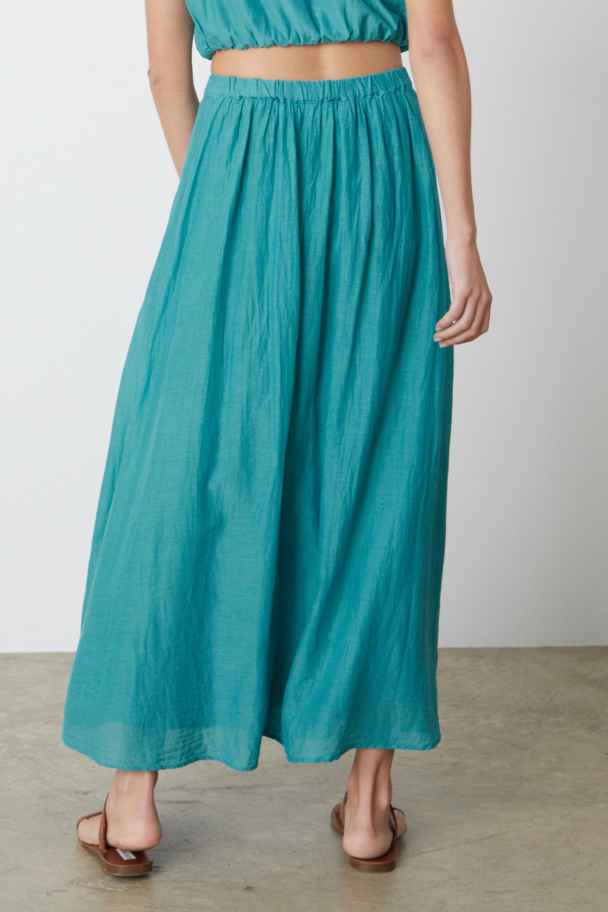   The back view of a woman wearing the Velvet by Graham & Spencer MARIELA MAXI SKIRT. 