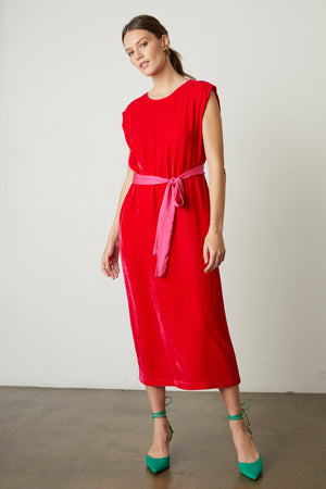a woman wearing a KANDACE SILK VELVET MAXI DRESS by Velvet by Graham & Spencer and pink heels.