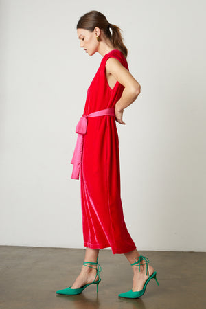 A woman wearing a KANDACE SILK VELVET MAXI DRESS by Velvet by Graham & Spencer and pink heels.