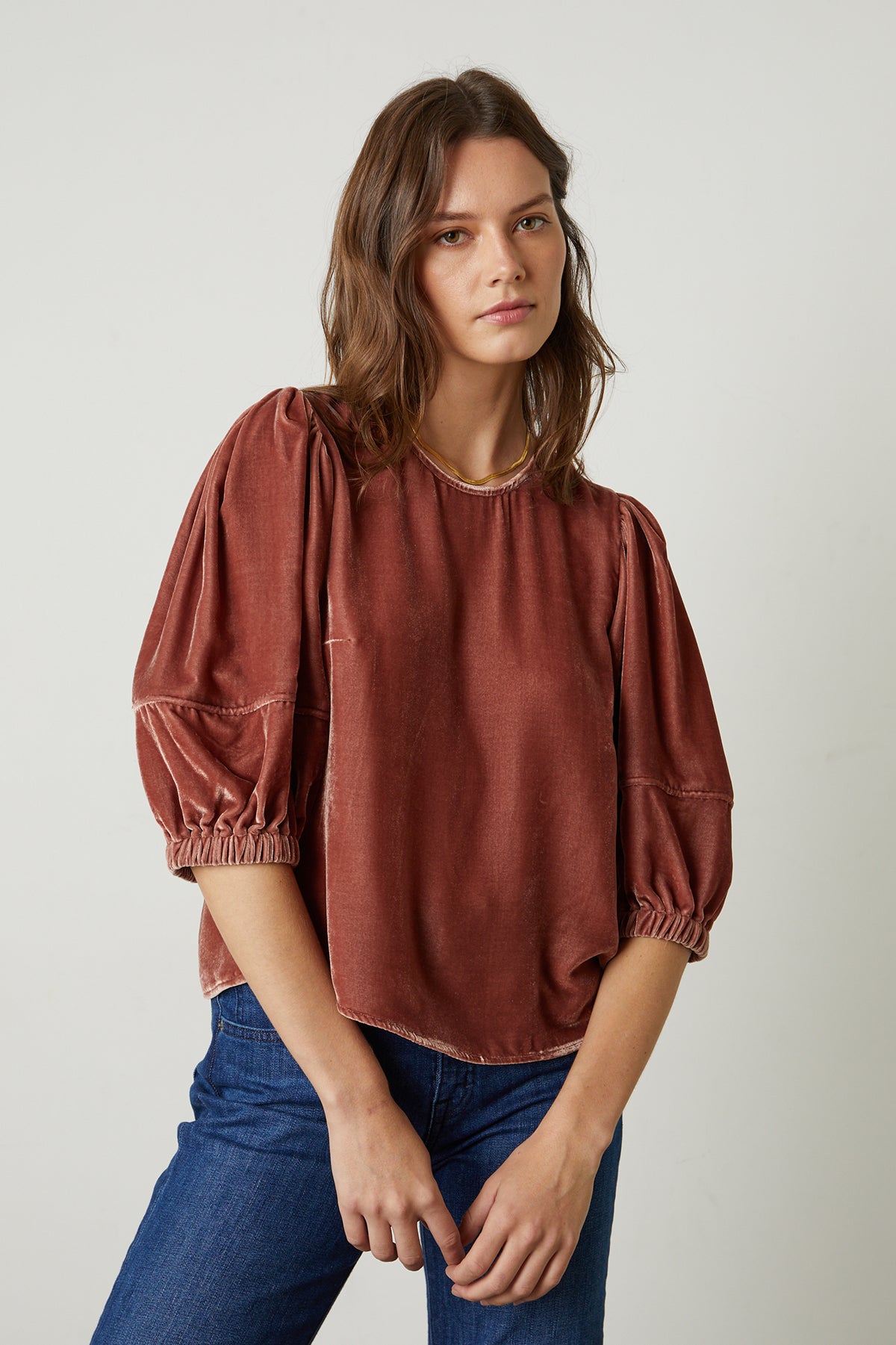 The model is wearing a Velvet by Graham & Spencer Nancy Silk Velvet Puff Sleeve Top with sleeve cuffs.-25735375421633