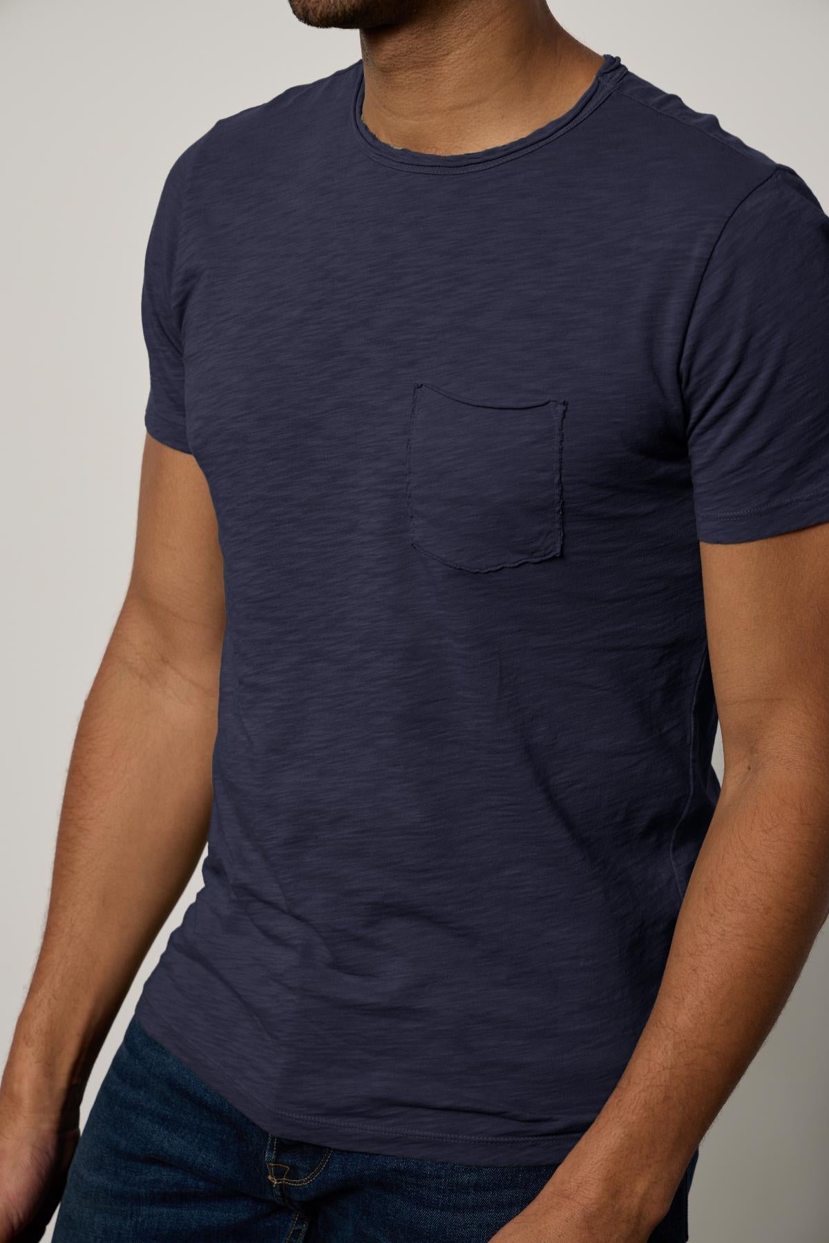 Man wearing a Velvet by Graham & Spencer CHAD TEE with a chest pocket, standing against a neutral background.-26146501329089