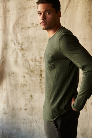 Victor Crew Neck Long Sleeve tee in palm green with dark grey sweatpants side