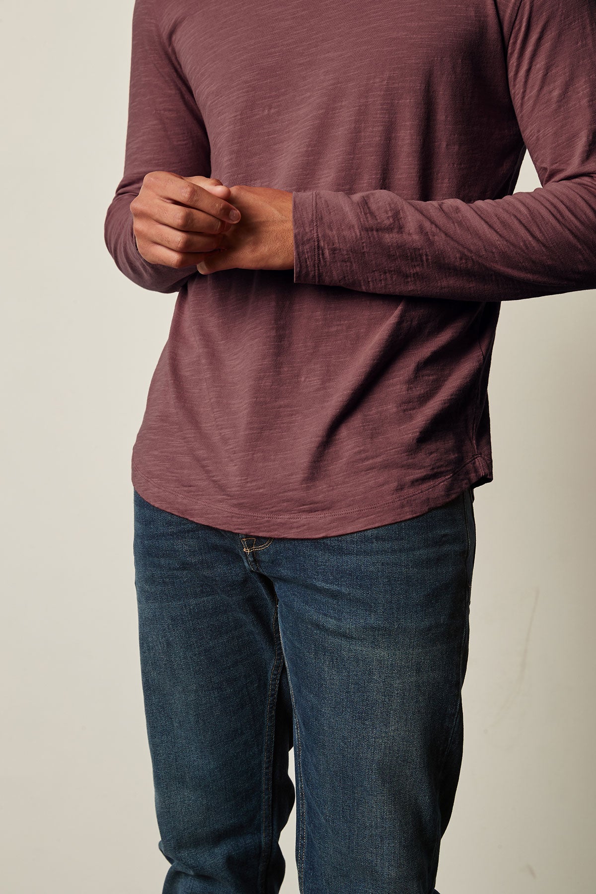 A man wearing jeans and a KAI CREW NECK TEE by Velvet by Graham & Spencer, creating a vintage-feel with the perfect layering piece.-25793842512065