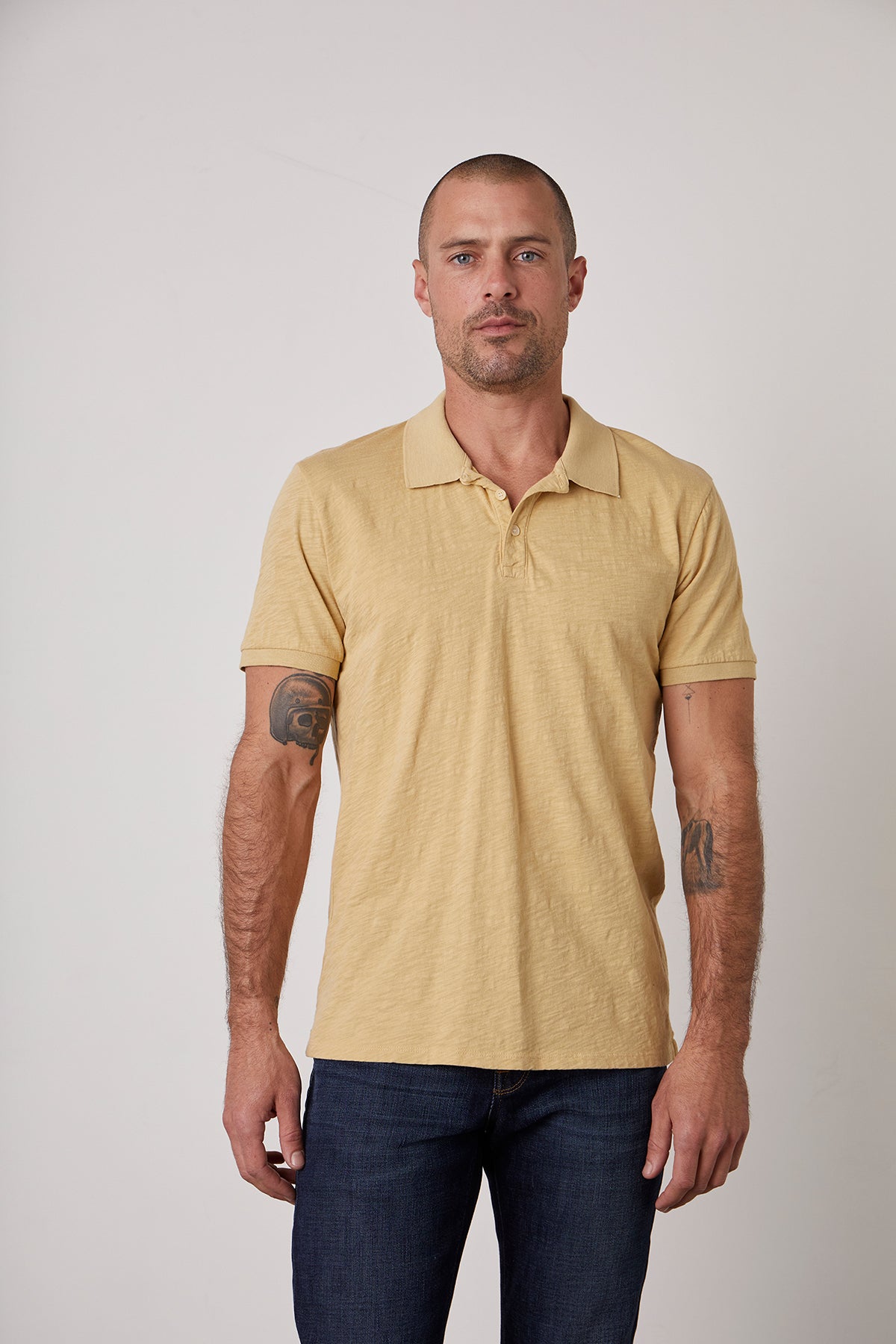 A man wearing a NIKO POLO by Velvet by Graham & Spencer, a classic polo-shirt silhouette in a yellow cotton slub.-25793857880257