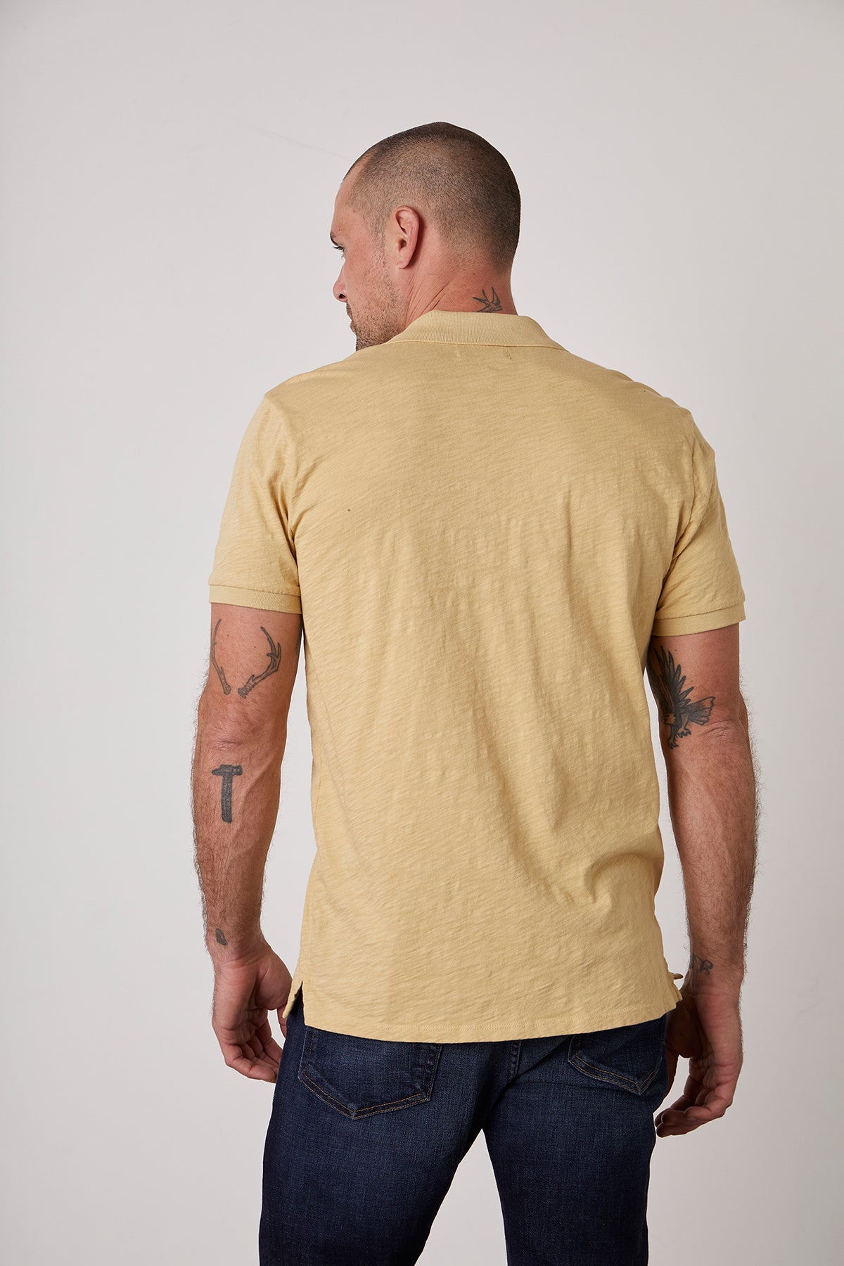The back of a man wearing a NIKO POLO silhouette in a yellow cotton slub t-shirt by Velvet by Graham & Spencer with a vintage-feel hand.-25793857945793