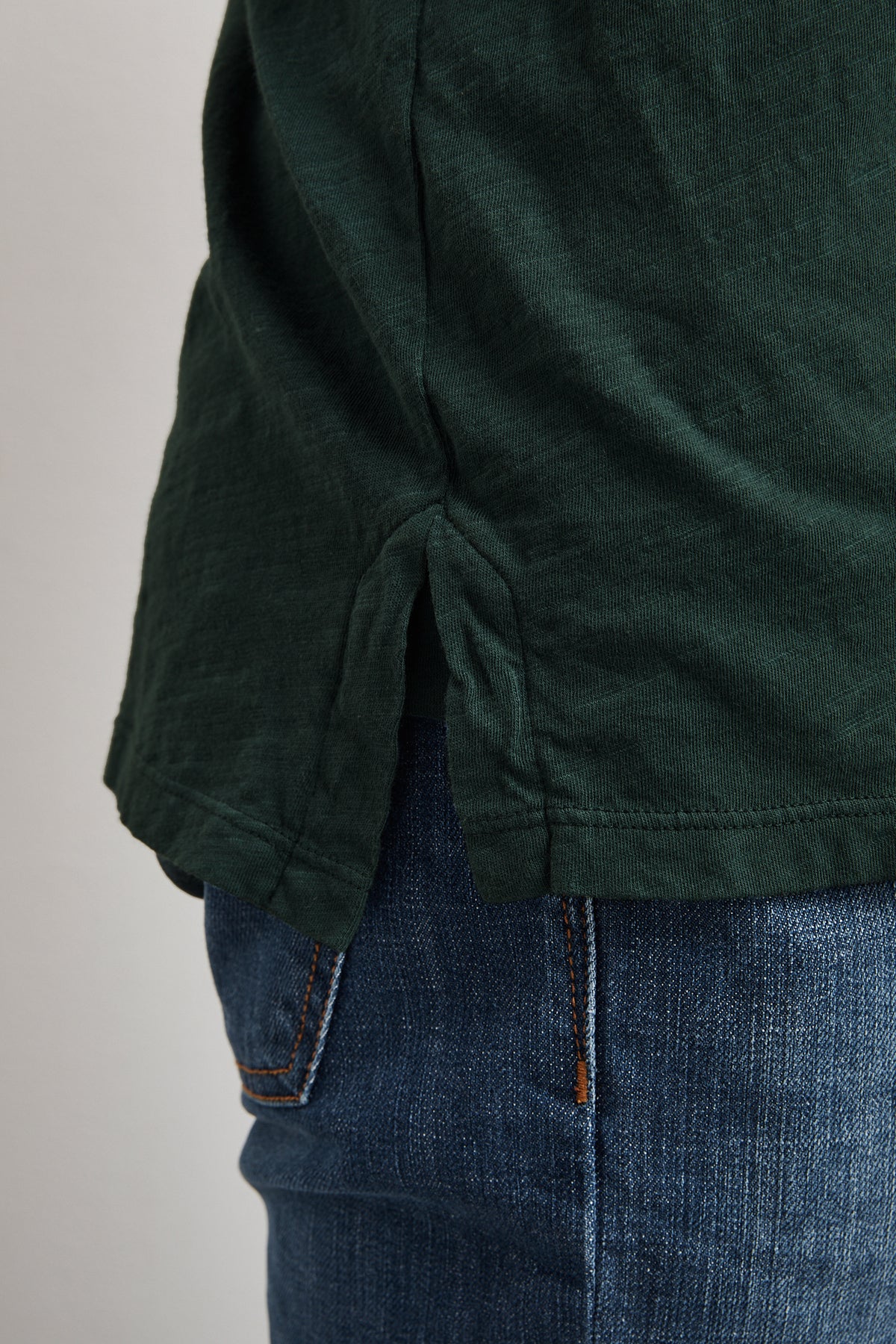 A man wearing jeans and a lightweight green Velvet by Graham & Spencer RANDALL COTTON SLUB POLO, a closet essential.-1012297367633