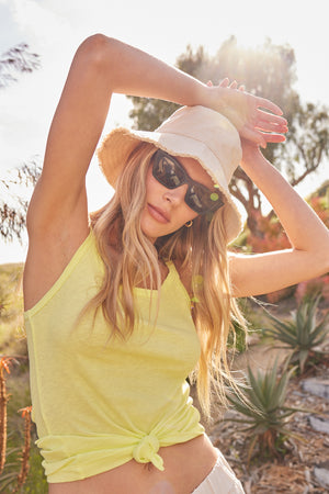 A woman wearing Velvet by Graham & Spencer sunglasses and a Velvet by Graham & Spencer fringed bucket hat in the desert.