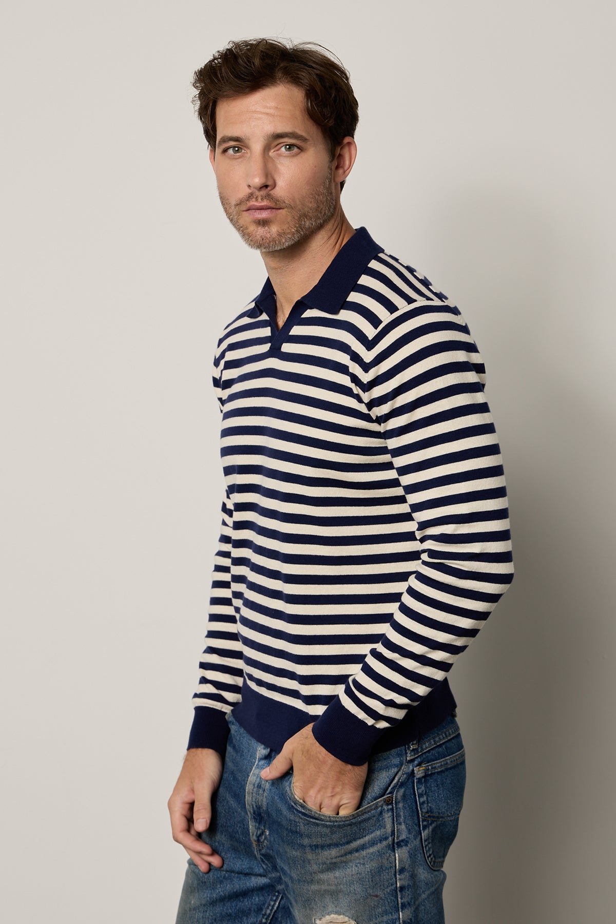 A man wearing the Velvet by Graham & Spencer Ricky striped polo shirt and jeans.-25943739891905