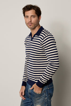 A man wearing the Velvet by Graham & Spencer Ricky striped polo shirt and jeans.