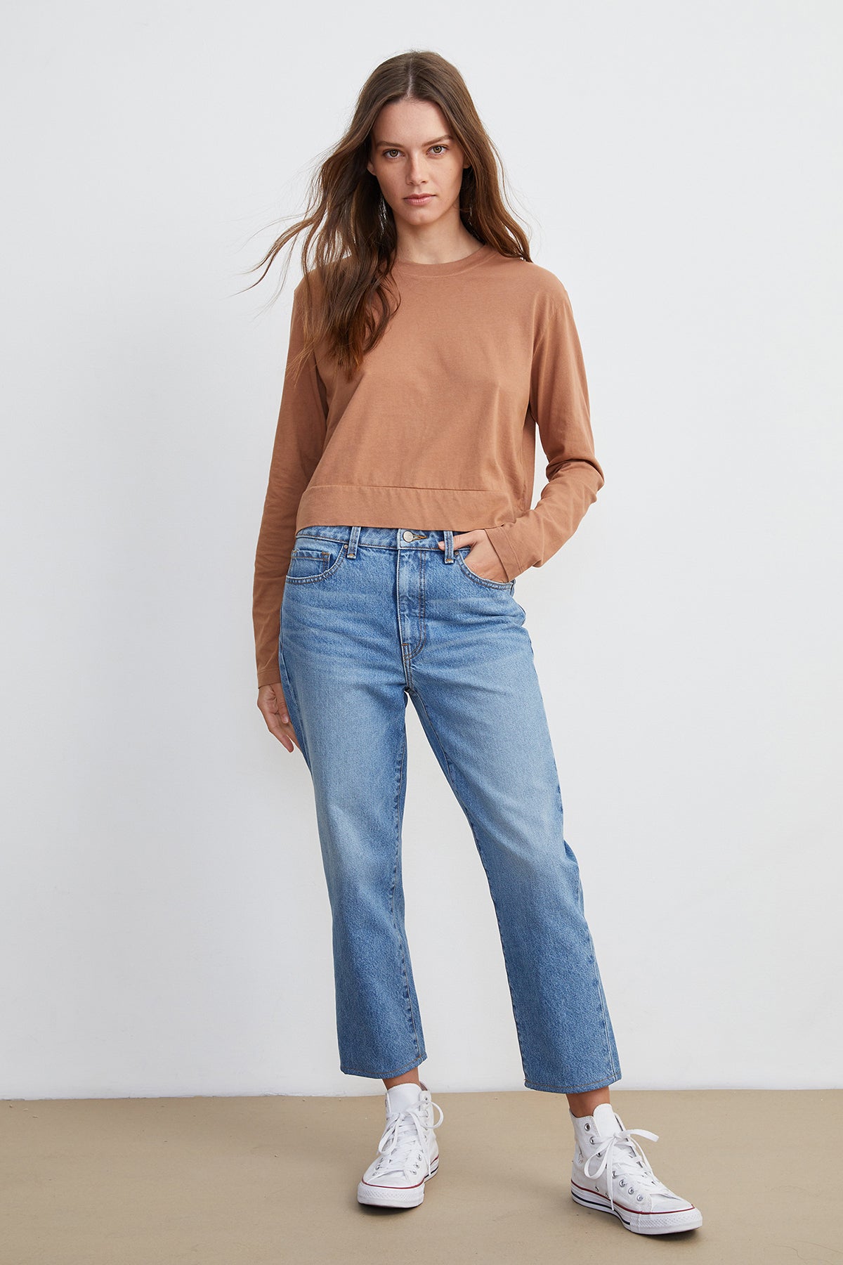 The model is wearing a tan sweatshirt and Velvet by Graham & Spencer's VICTORIA HI RISE STRAIGHT LEG JEAN during the weekend in Los Angeles.-7933097148497