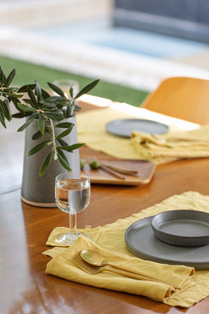 A LINEN PLACEMAT from Jenny Graham Home on a wooden table is a simple and stylish way to accessorize the dining area.