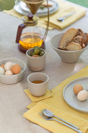 A yellow LINEN PLACEMAT from Jenny Graham Home on a table can accessorize and enhance the overall appearance.
