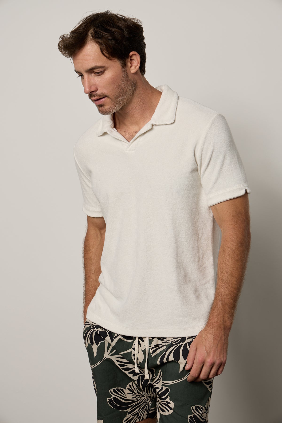 Man wearing Boris Polo in ecru terry with hand in pocket of Colt Shorts in catalina print front-26266324402369