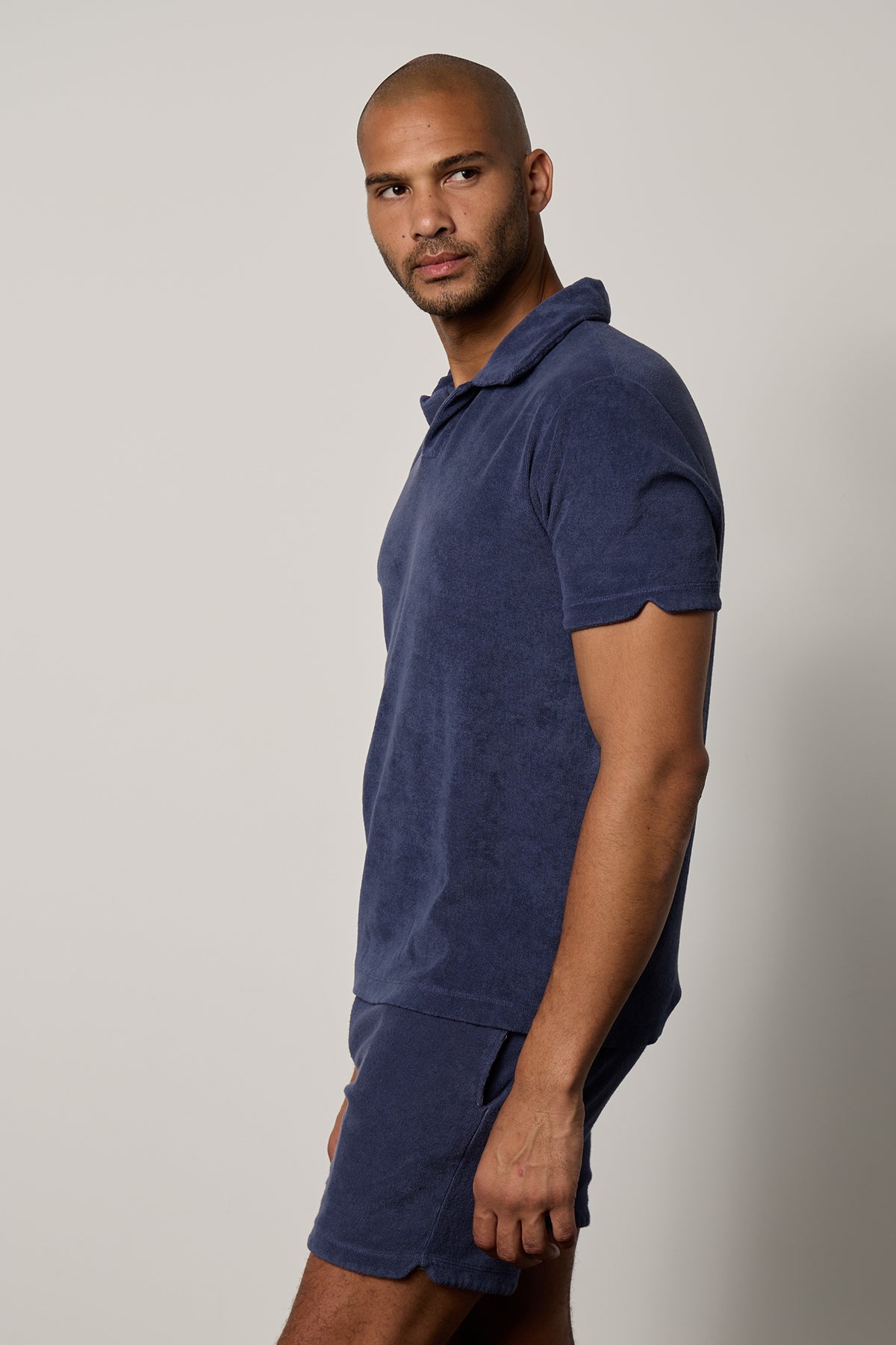   A man wearing a Velvet by Graham & Spencer blue Boris Terry Polo shirt and shorts. 