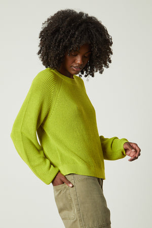 a woman wearing a Velvet by Graham & Spencer LINAH CREW NECK SWEATER and green pants.