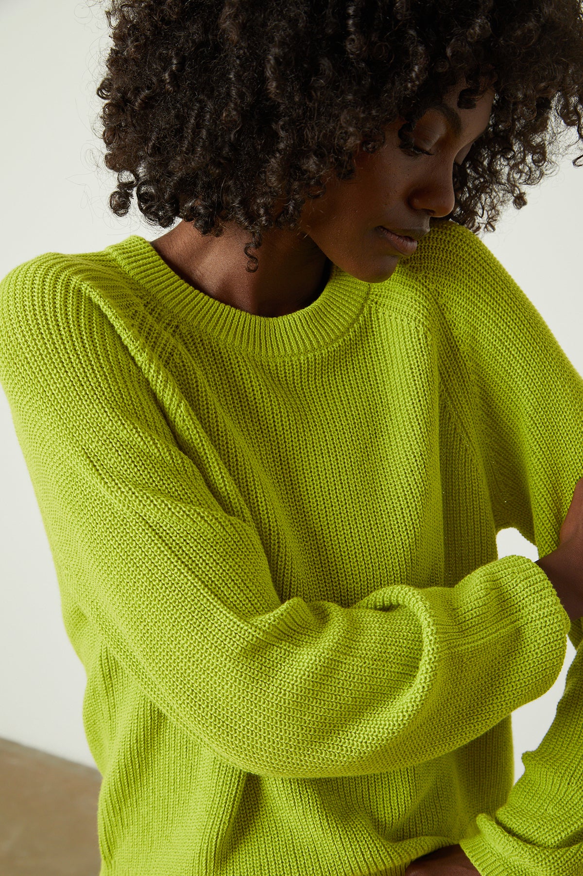   a woman wearing a LINAH CREW NECK SWEATER by Velvet by Graham & Spencer. 