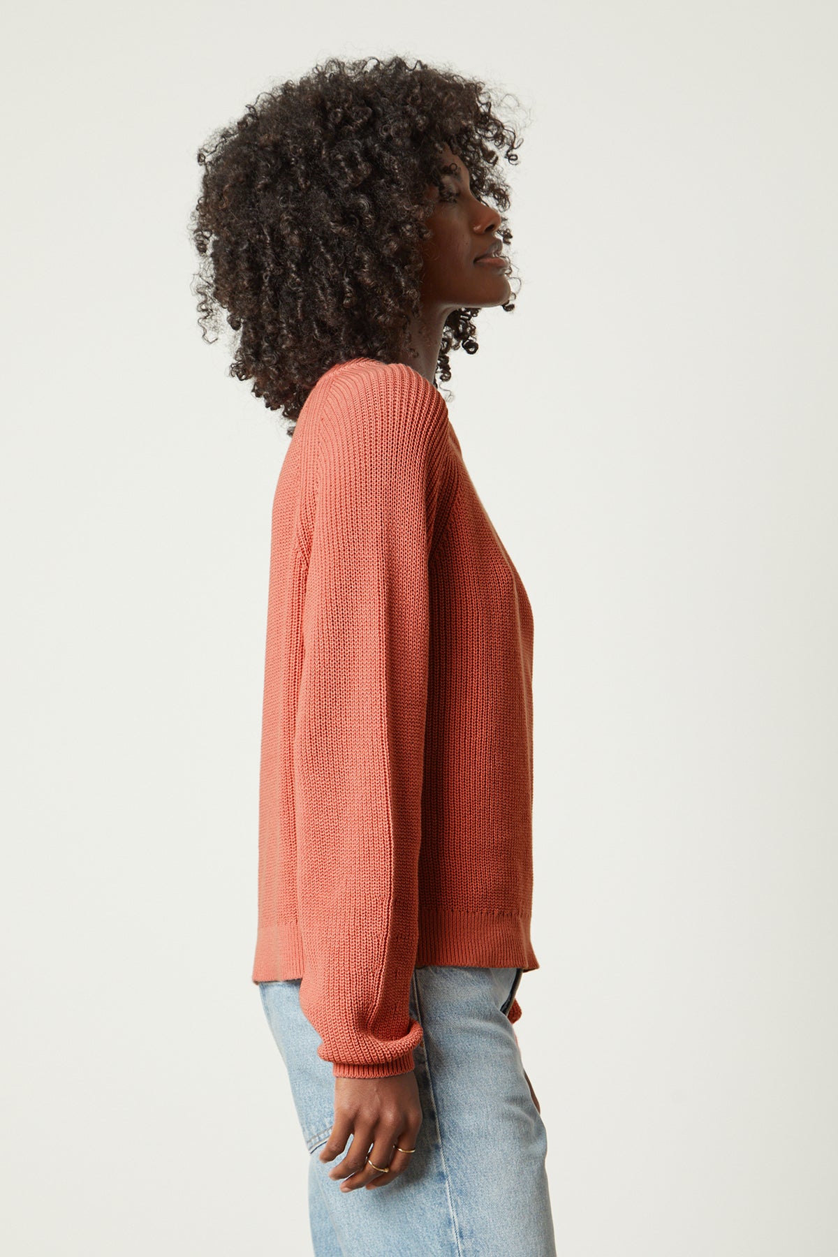   The back view of a woman wearing the Velvet by Graham & Spencer LINAH CREW NECK SWEATER and jeans. 