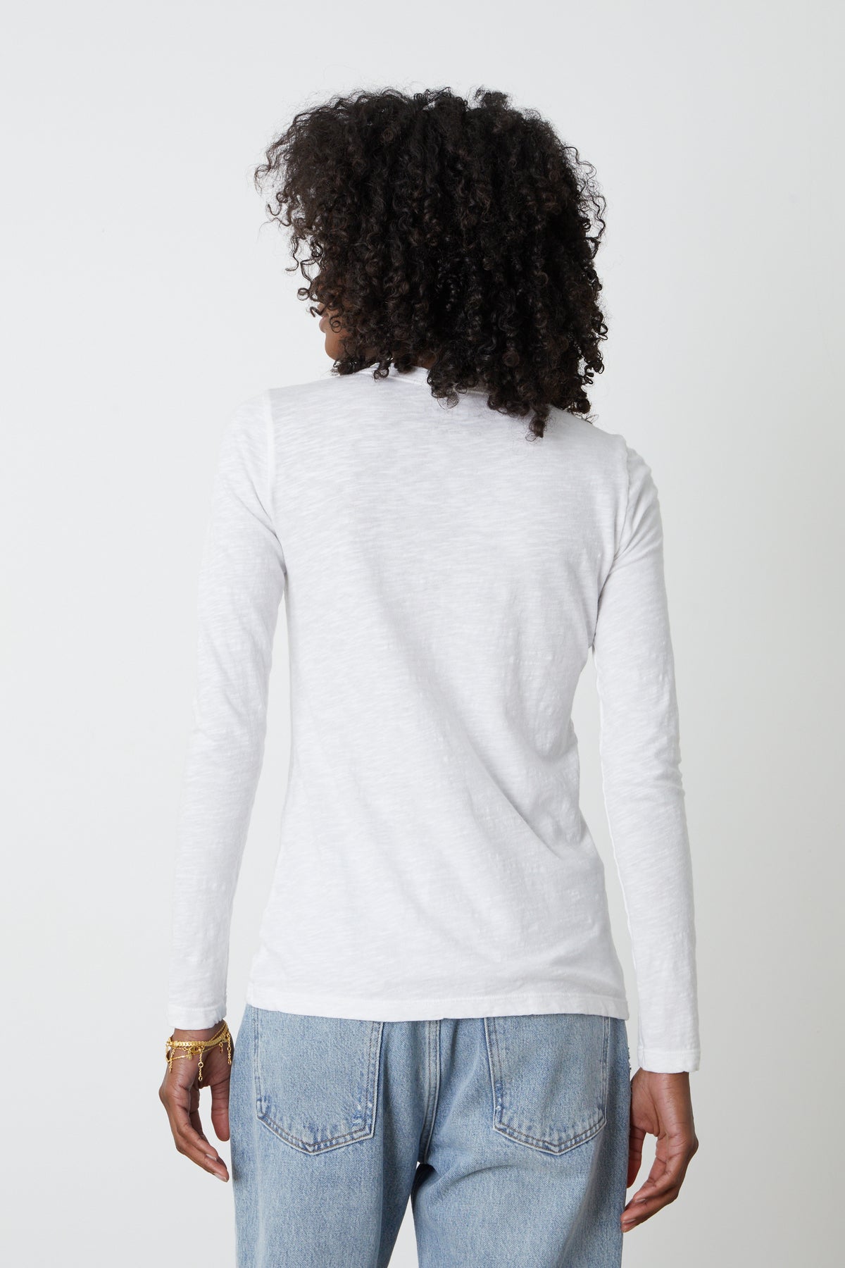 the back view of a woman wearing jeans and a Velvet by Graham & Spencer LIZZIE ORIGINAL SLUB LONG SLEEVE TEE.-26235766177985