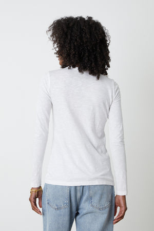 the back view of a woman wearing jeans and a Velvet by Graham & Spencer LIZZIE ORIGINAL SLUB LONG SLEEVE TEE.
